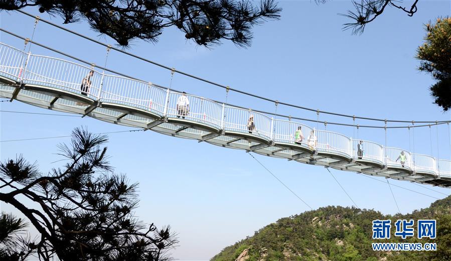 5月19日,游客在山东省临沂市平邑县蒙山龟蒙景区玻璃桥上游览.