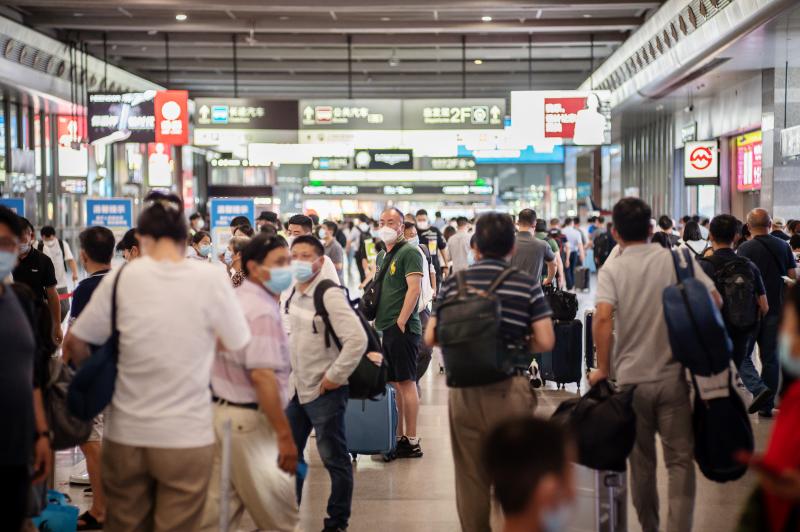 防疫形势趋紧,上海虹桥火车站旅客流量略有下降,出站口工作人员一字排