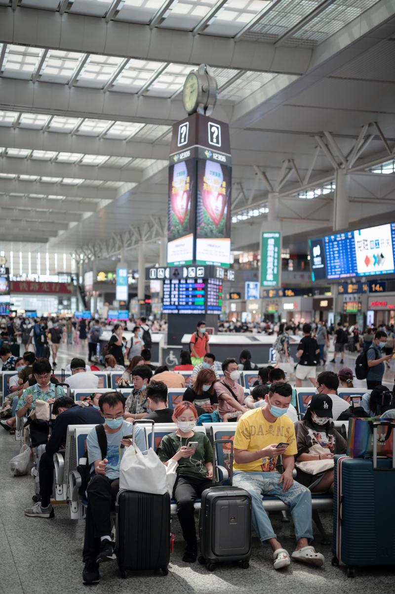 防疫形势趋紧,上海虹桥火车站旅客流量略有下降,出站口工作人员一字排