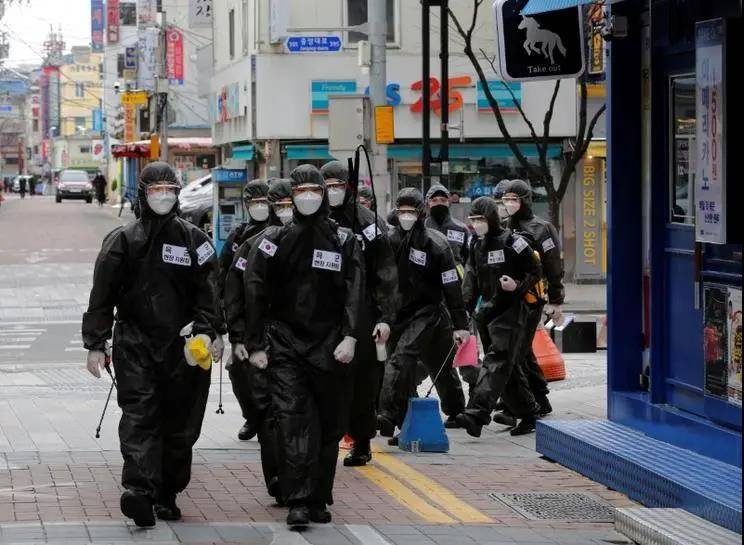 △ 3 月 15 日，韩国士兵穿着防护服，在市中心对道路及建筑物消毒。图片来源 | 路透社，摄影 | Kim Kyung-Hoon