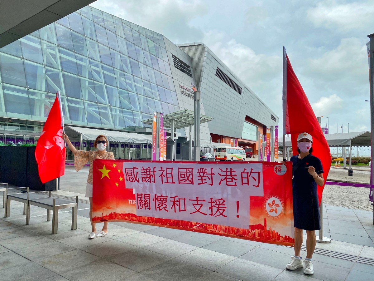 北京日报客户端|国家队来了！核酸检测“先遣队”抵港，市民挥国旗欢迎