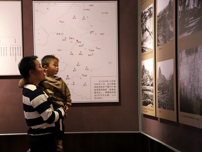 潘学军带着小孩在参观红七军苗山陈列馆。李菲菲摄.JPG