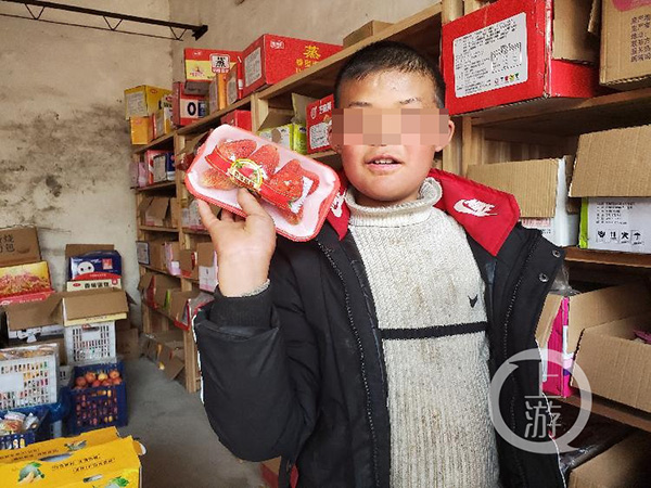 2月24日，永丰县石马镇严辉村，范小勤的哥哥范小勇在村中小卖部挑选水果。