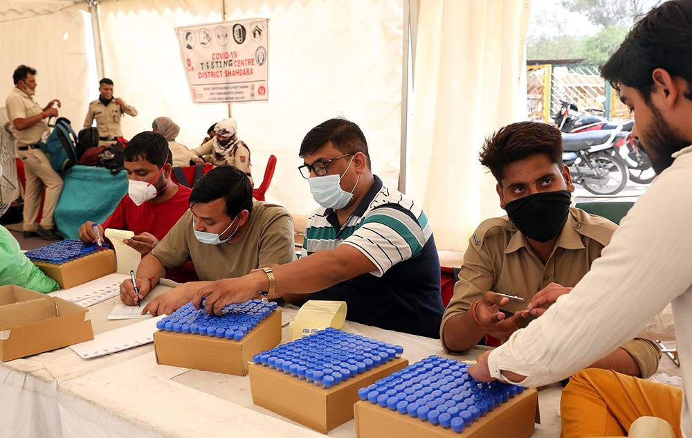 当地时间2021年4月8日，印度新德里，医护人员准备为民众进行新冠病毒检测。澎湃影像 图
