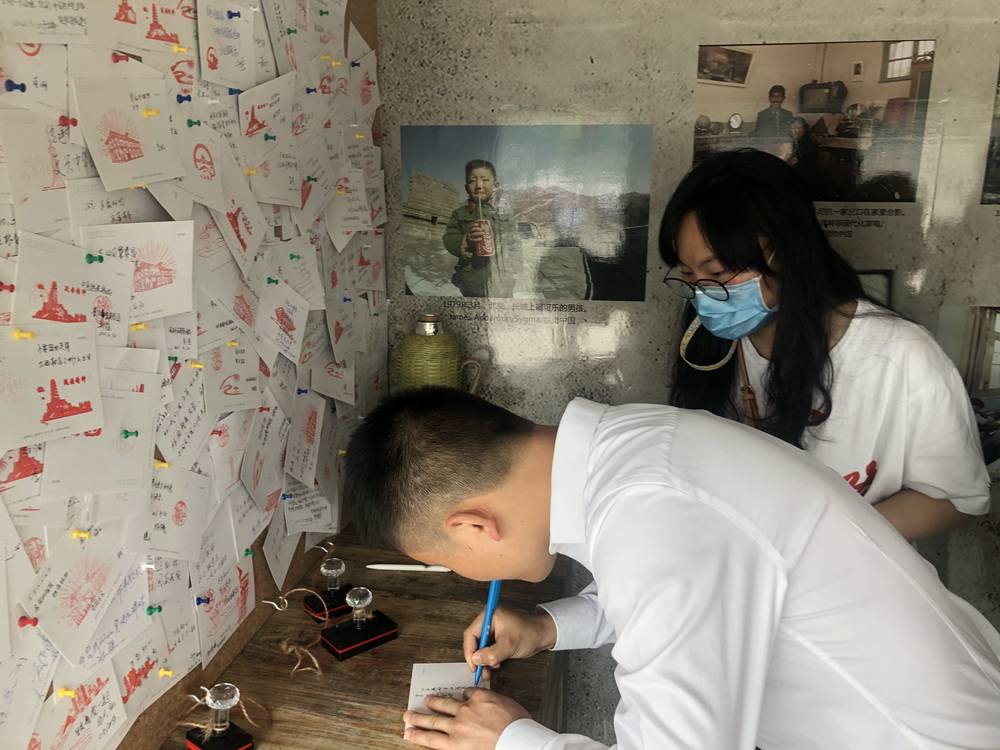 李小辉在写明信片。