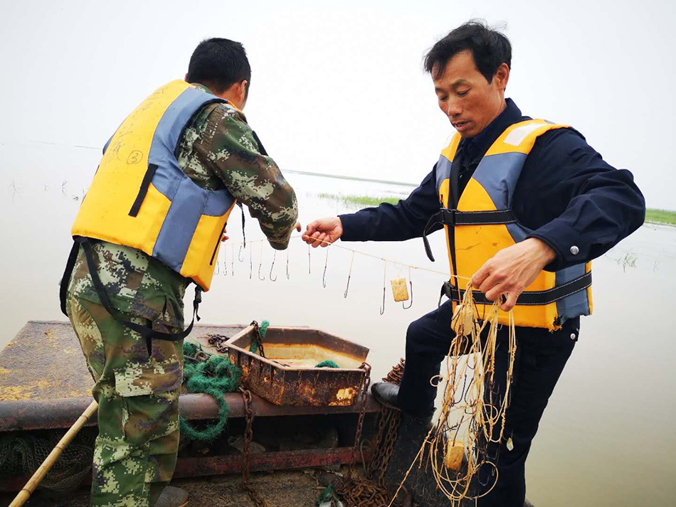 志愿巡湖时,发现水上用于非法捕捞的渔网。 蒋忆 摄