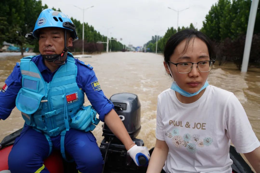 7月22日,新华社记者姚竣译乘冲锋舟前往郑州阜外华中医院采访.