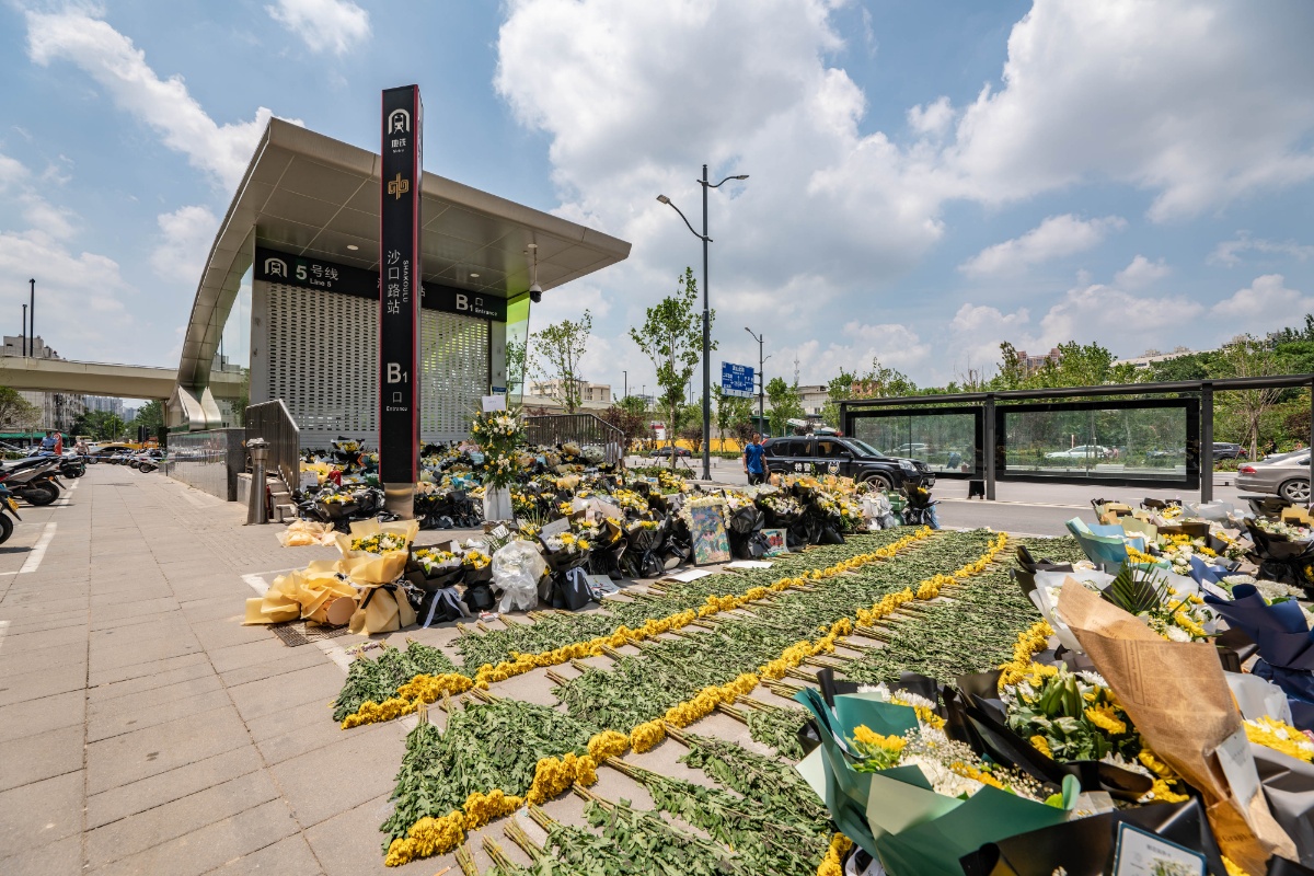 郑州5号线沙口路站地铁口围挡被市民拆除 入口摆满鲜花和卡片祭奠逝者