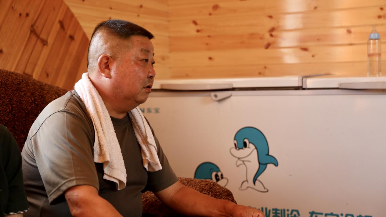 徐大勇接受采访，讲述郝家冲村旧貌变新颜背后的故事。吴雨晴 摄