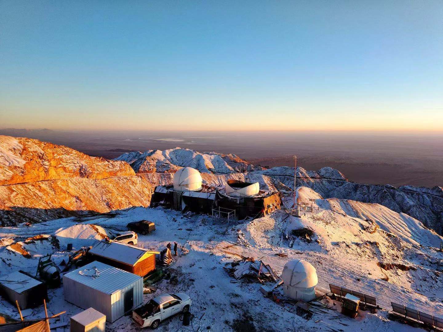 赛什腾山建设工地沐浴在日落的余晖中,水平线之下是