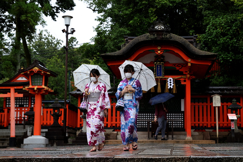 当地时间2021年8月20日，日本京都，民众戴口罩雨中行走。 视觉中国 图