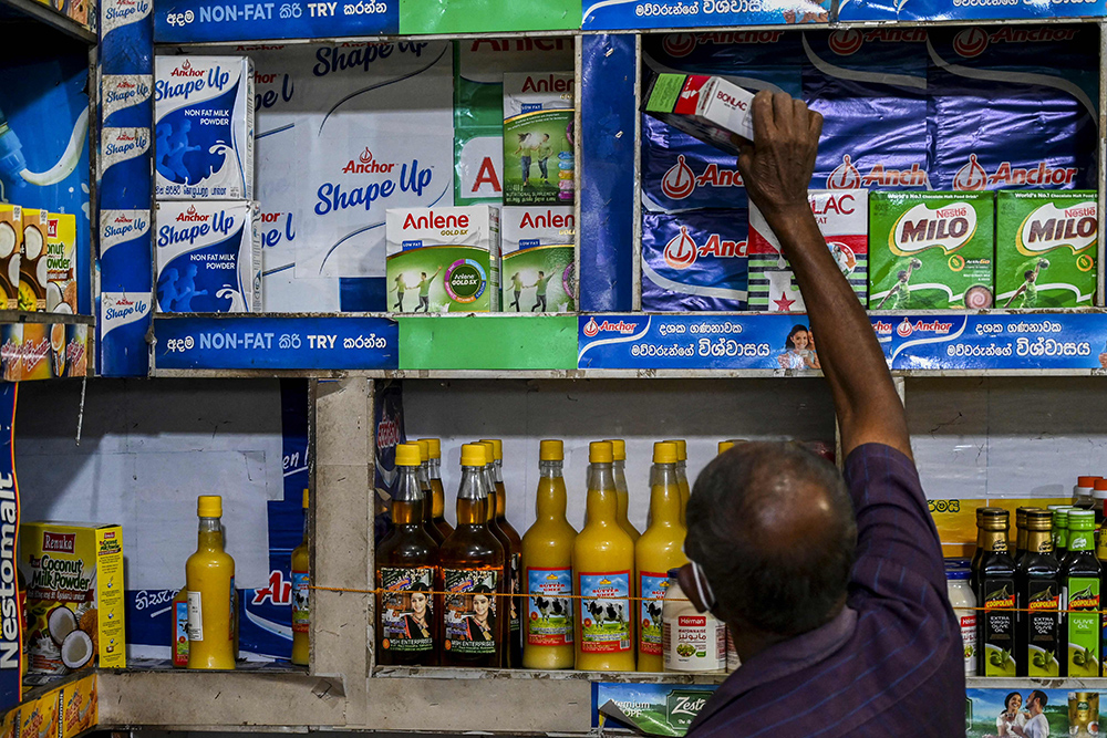 2021年8月19日，斯里兰卡科伦坡的一家商店里，一名店主拉出一包牛奶。人民视觉 图