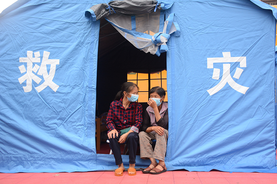 9月16日,泸县集福镇龙脑桥中心小学安置点,两位老人在帐篷里聊天。