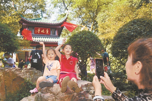 10月1日，长沙市岳麓山景区，游客在爱晚亭前拍照。当天，经过约2个月的全封闭式修缮，爱晚亭与游客重新“见面”。  湖南日报·新湖南客户端 图