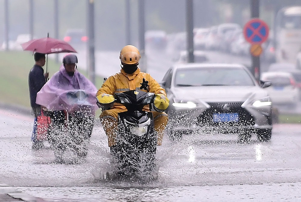 2021年10月3日,沈阳遭遇暴雨天气,市民冒雨出行。 视觉中国 图
