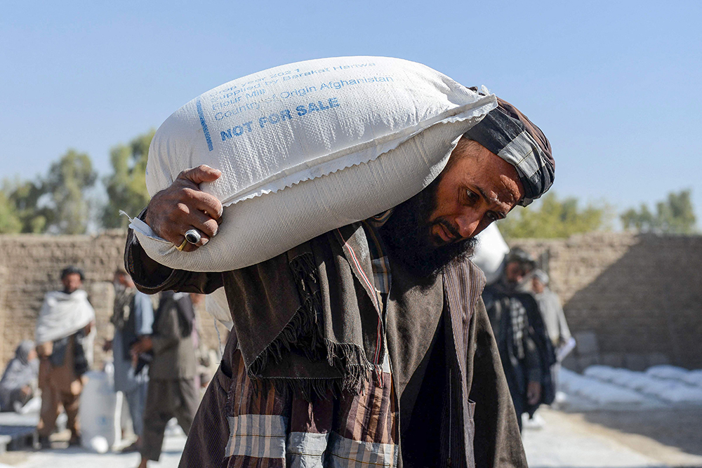 当地时间2021年10月19日,阿富汗坎大哈,一名男子扛着世界粮食计划署
