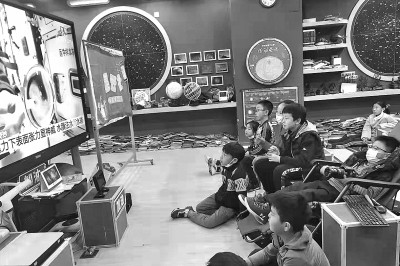 2021年12月9日,北京中关村第二小学的同学们在教室观看“太空教师”翟志刚、王亚平、叶光富在中国空间站为广大青少年带来的太空科普课。光明图片