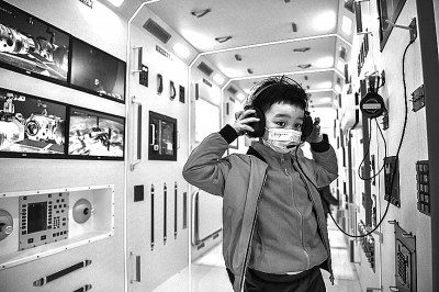 2021年12月12日,小朋友在成都武侯区潮音社区的社区太空探索中心中国空间站核心舱模型内体验。新华社发