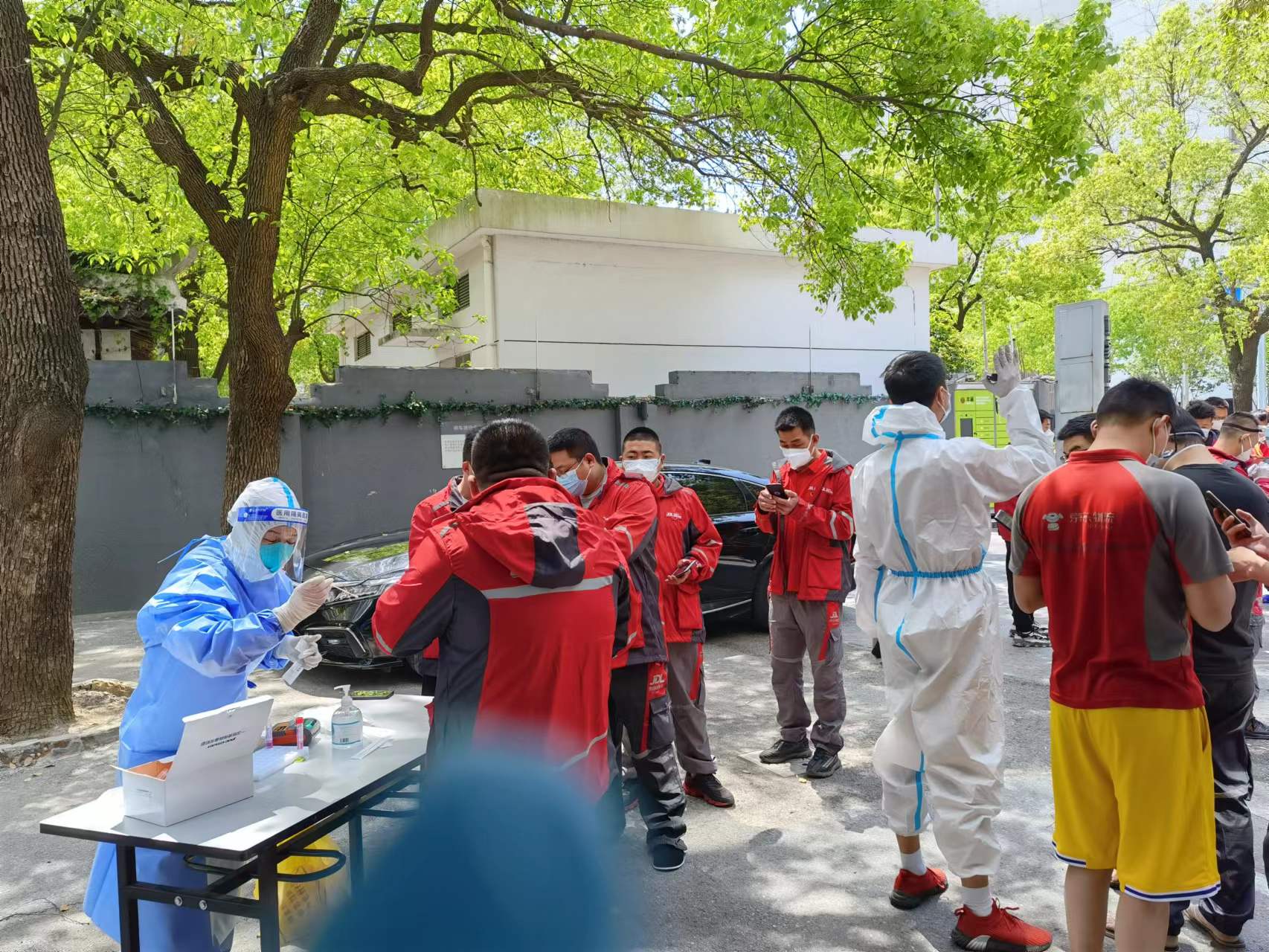 京东快递员在上海某如家酒店门口排队统一做核酸。
