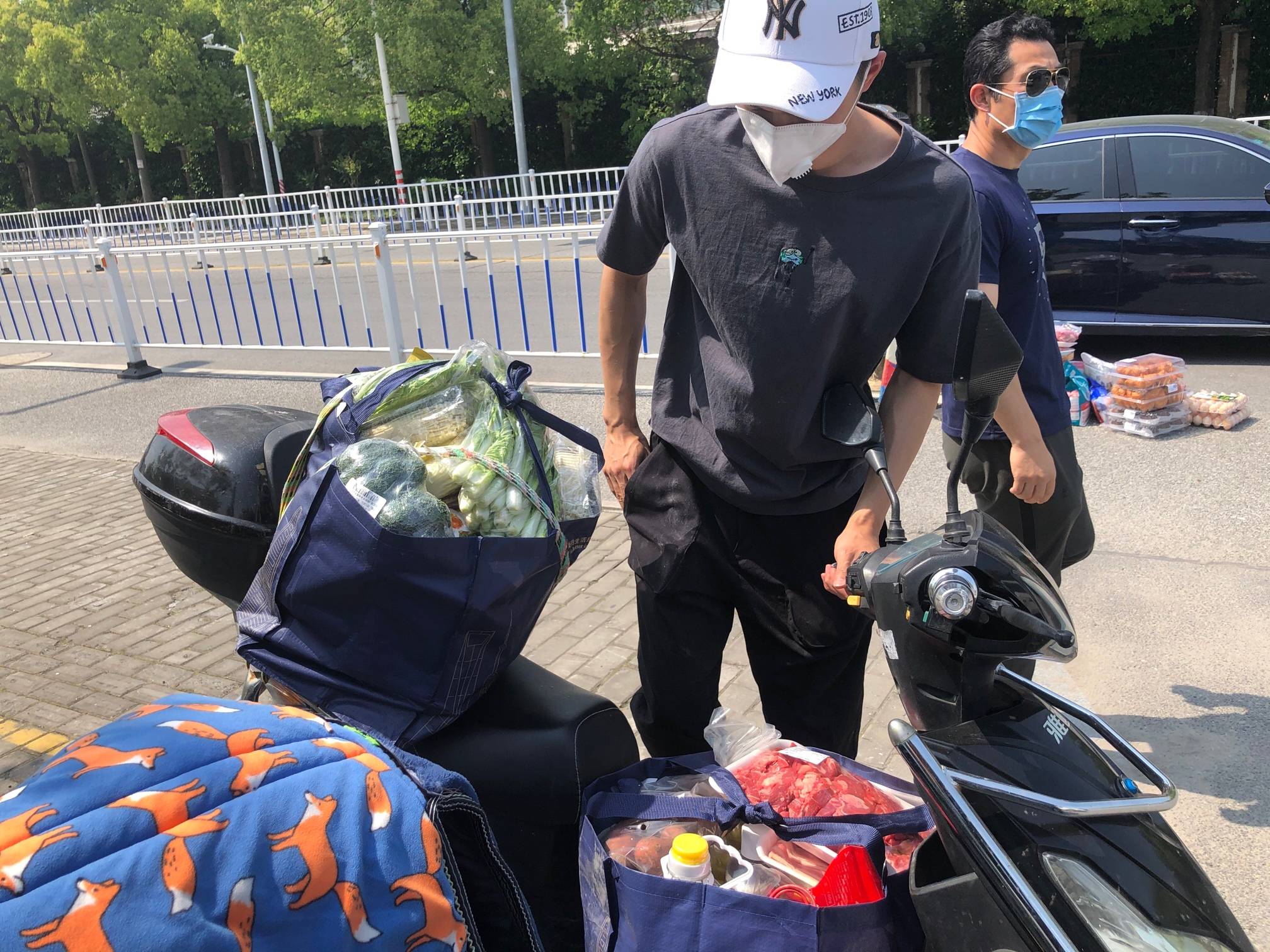 居民将所购商品放在电瓶车上。