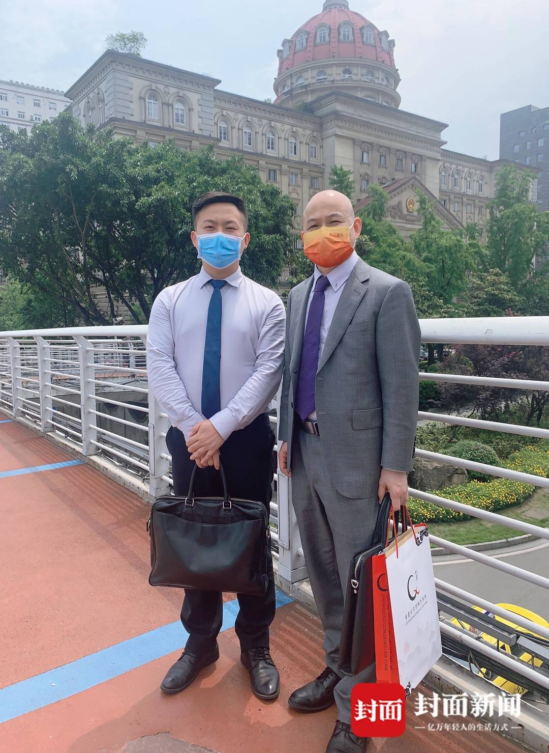 王云的两位代理律师在重庆市高院外合影。