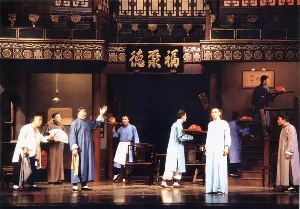 1988年版《天下第一楼》剧照,林连昆(前举手者)饰演善于迎来送往的堂头常贵