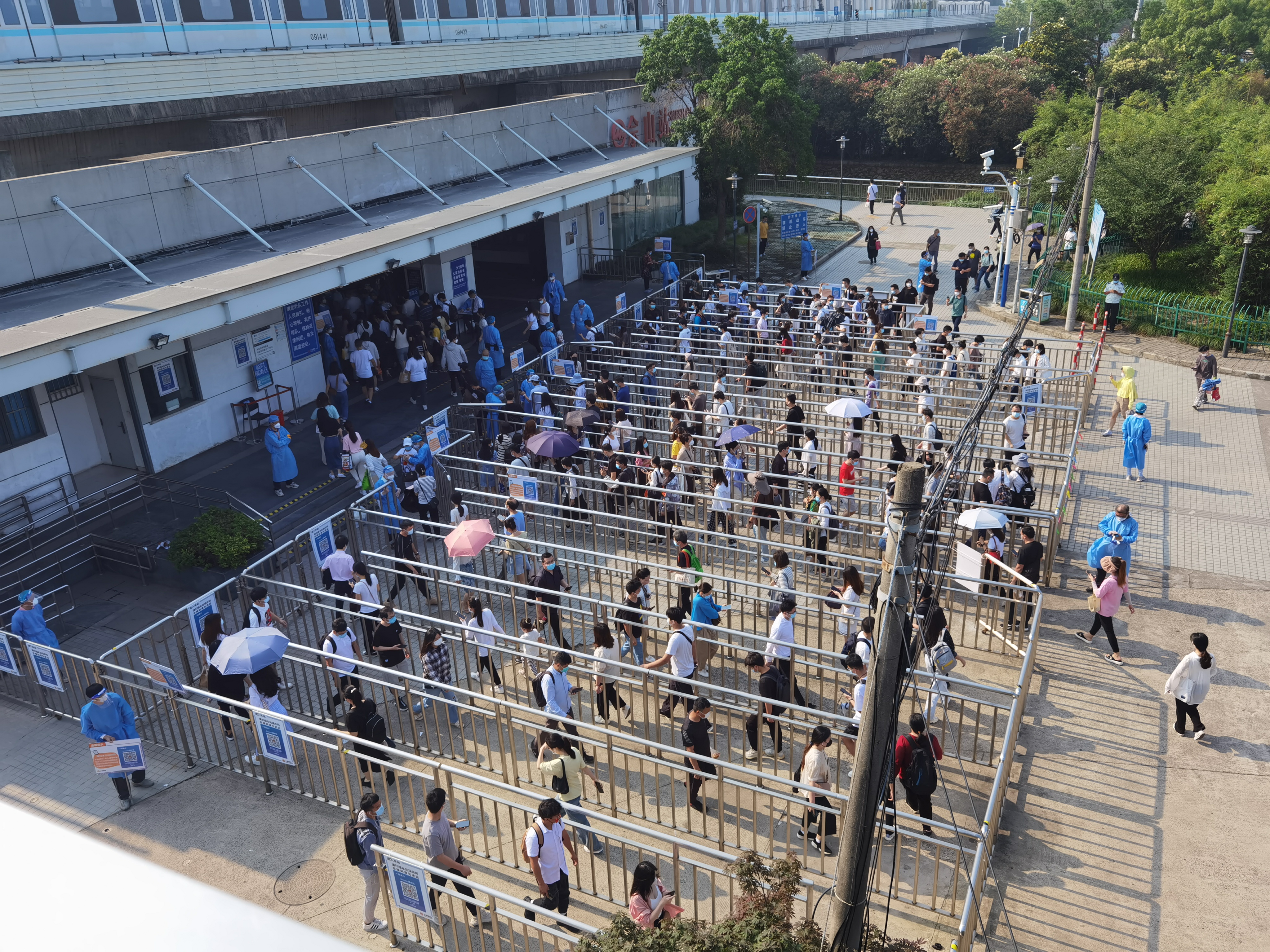 6月15日上午8点半左右，地铁9号线佘山站1号口外，乘客绕着蛇形栏杆有序进站。受访者供图