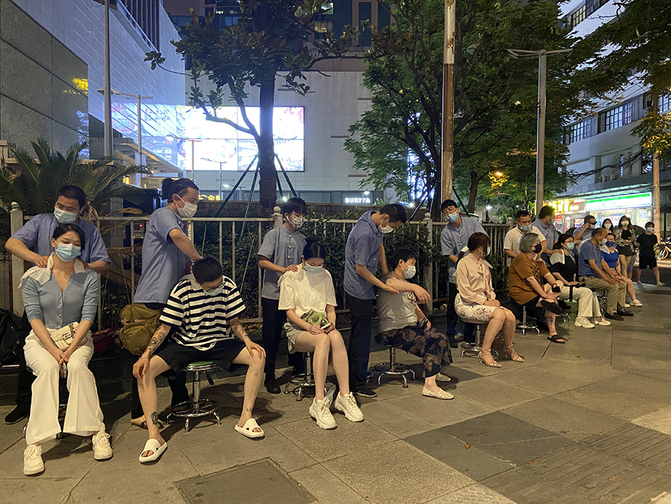 6月20日晚,按摩师在街头进行肩颈按摩。除标注外,本文图片均为澎湃新闻记者 陈悦 图