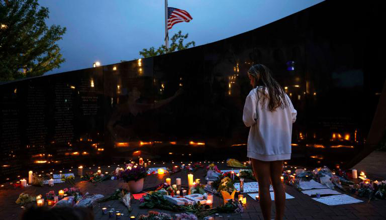 当地时间2022年7月5日,美国伊利诺伊州海兰帕克市,民众献花和点燃蜡烛悼念枪击案受害者。
