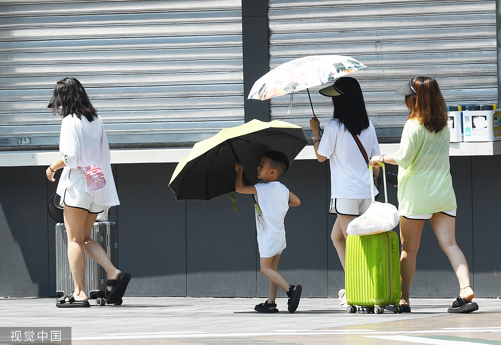 7月8日，重庆，市民顶着炎炎烈日出行。视觉中国 图