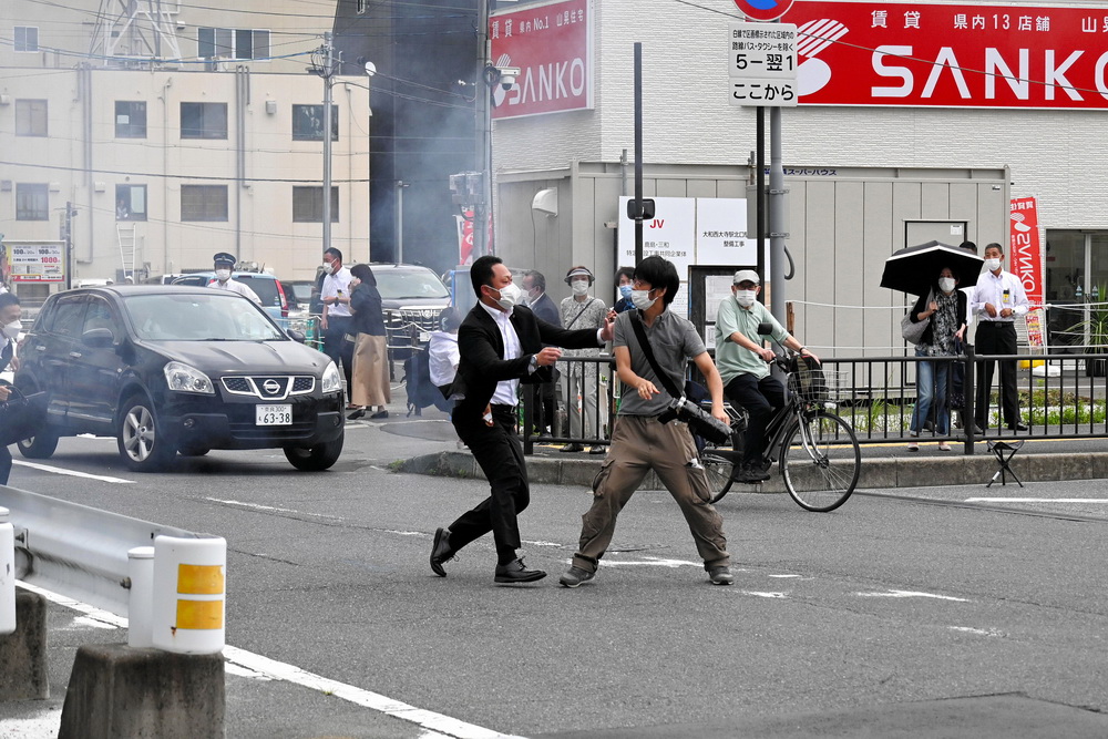7月8日，日本奈良市，安倍保镖试图捕捉一名疑似向安倍晋三开枪的男子（右）。  人民视觉 图