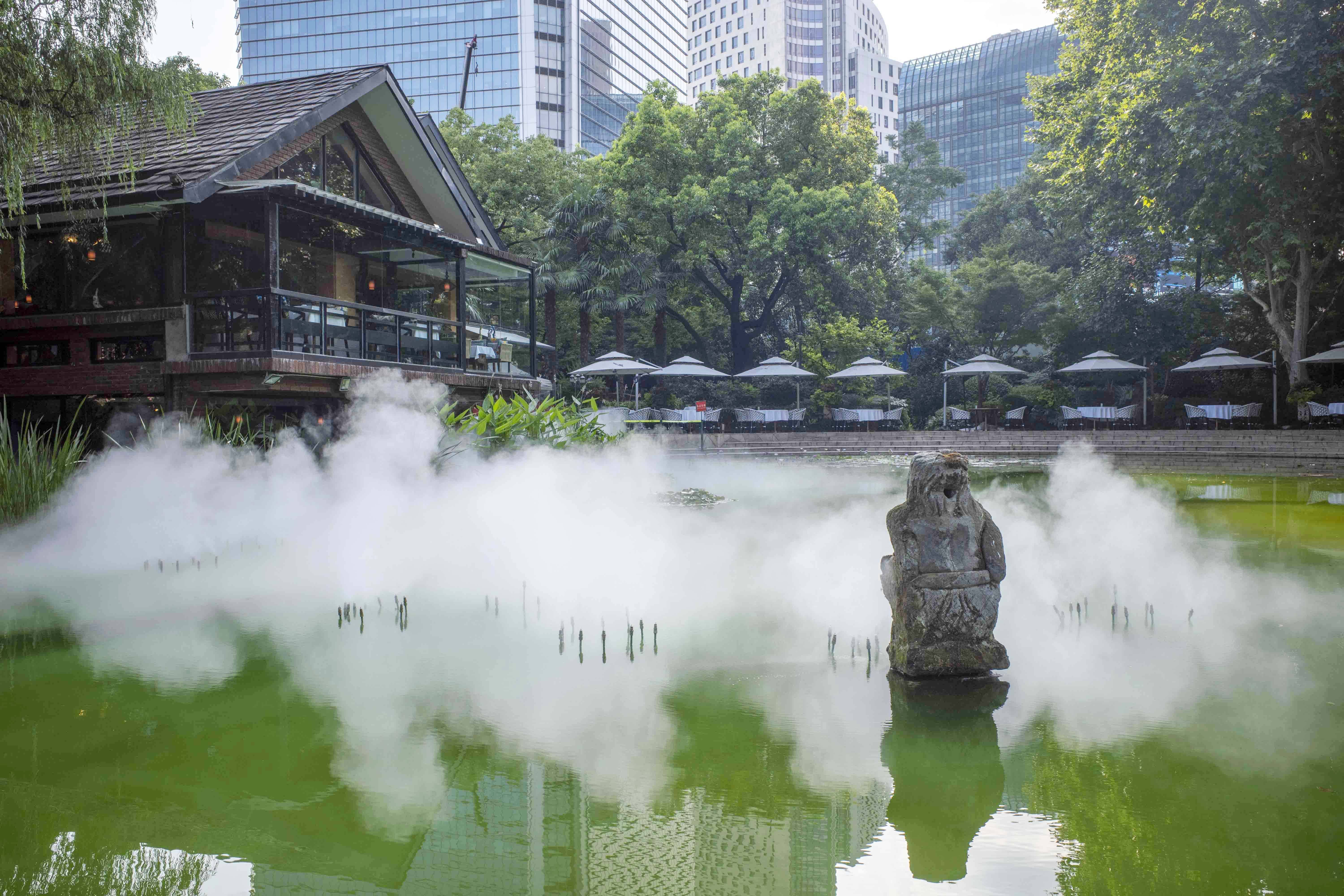 2022年7月11日，静安公园，水面上人工喷雾装置产生的水汽营造公园里的小气候。澎湃新闻记者许海峰图