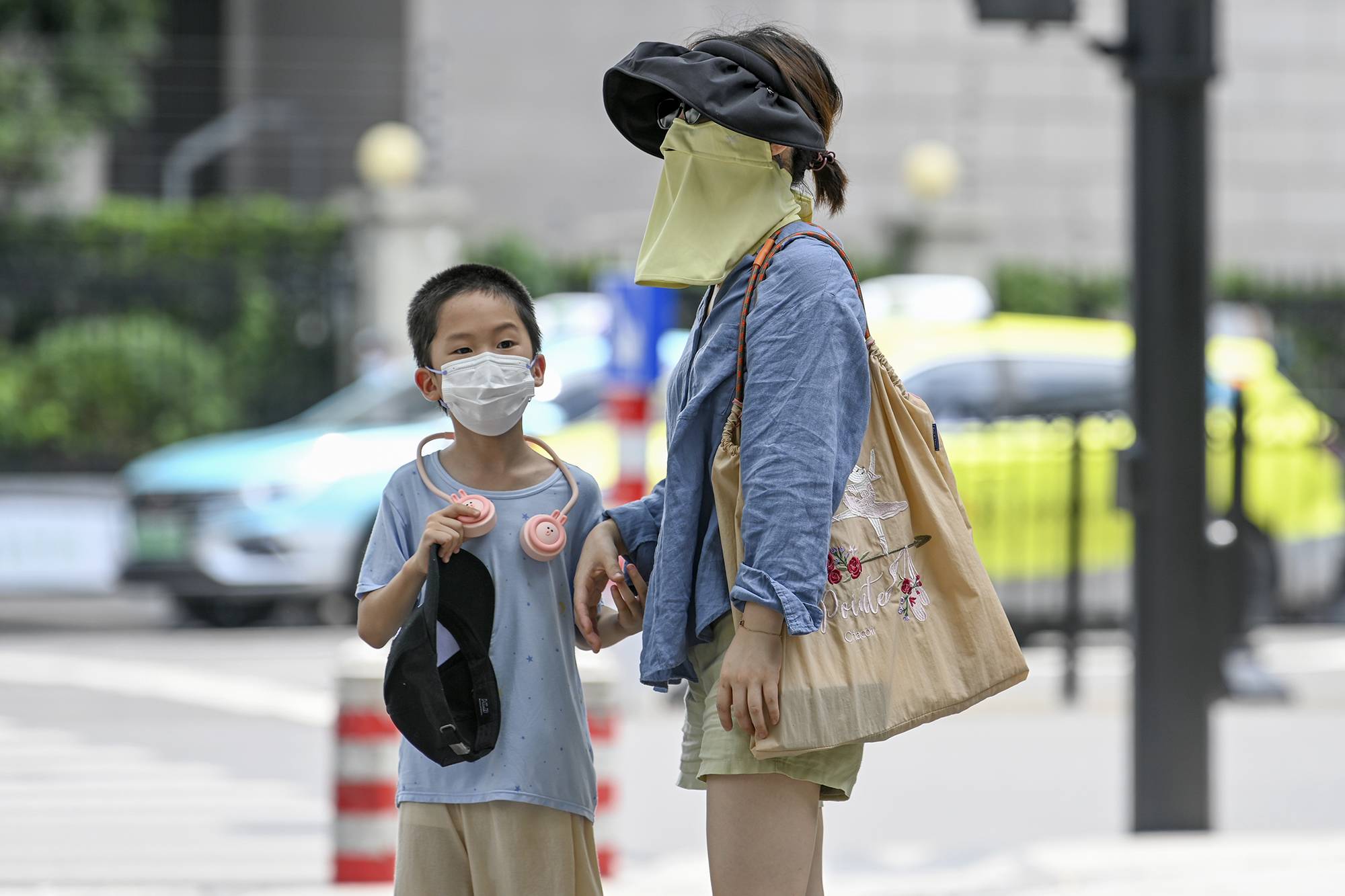 2022年7月11日，上海徐家汇，市民戴着防晒面具出行。澎湃新闻记者朱伟辉图
