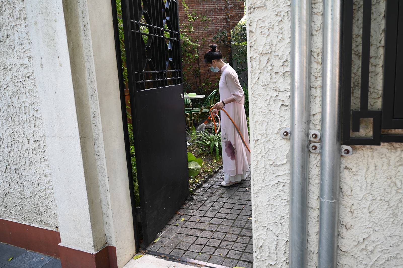 2022年7月11日，上海，武康路，女子在花园里浇水。澎湃新闻记者吴栋图