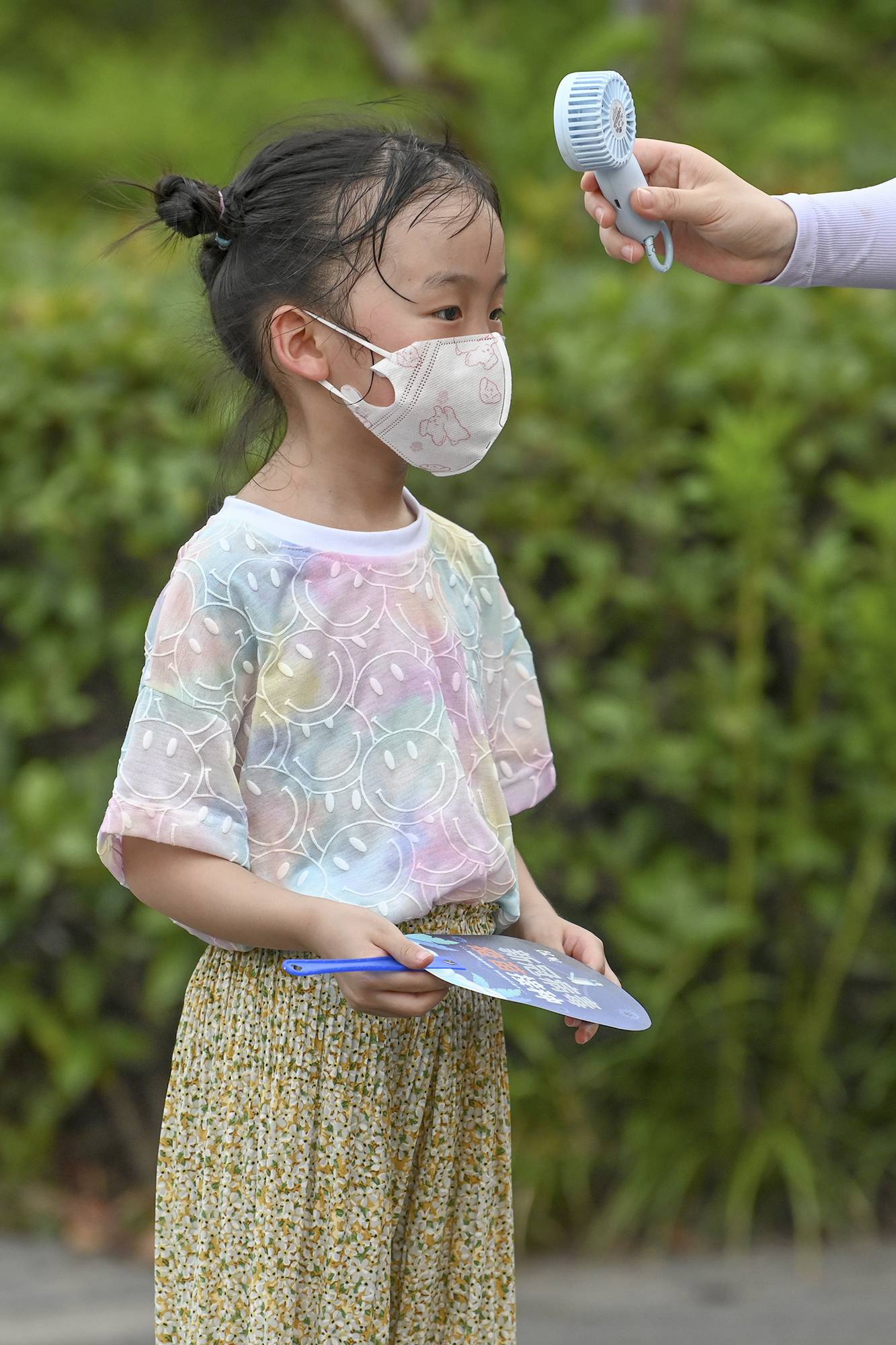 2022年7月10日,上海闵行某小区,家长用小电扇给满头大汗的孩子降温。澎湃新闻记者朱伟辉图