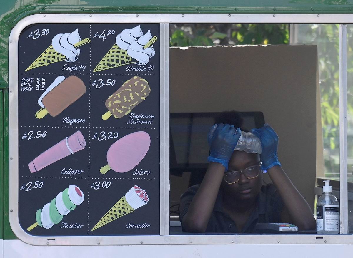 当地时间2022年7月19日,英国伦敦,当地遭遇高温热浪,卖冰淇淋的小贩用水给自己降温。