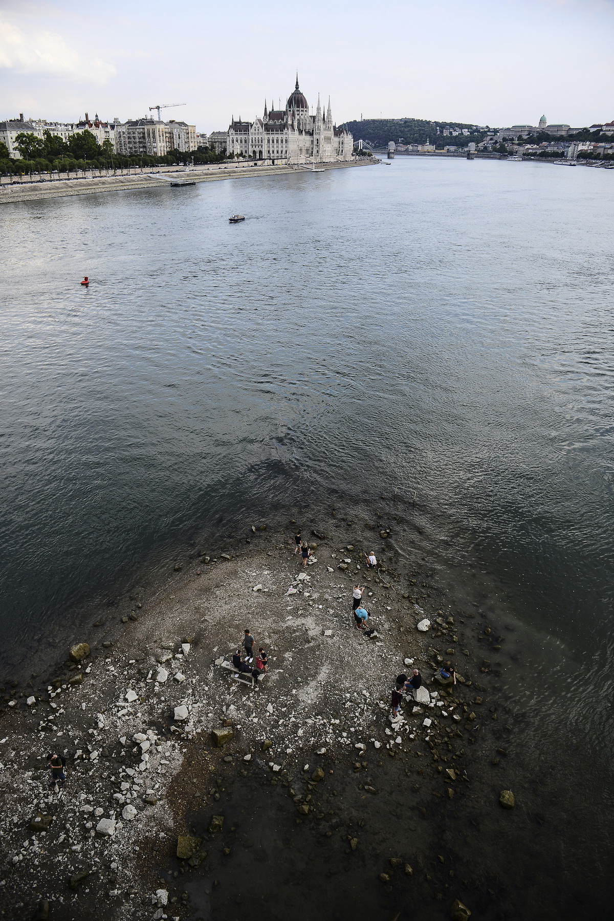 当地时间2022年8月9日，匈牙利布达佩斯，人们站在多瑙河水位较低的玛格丽特岛南端。