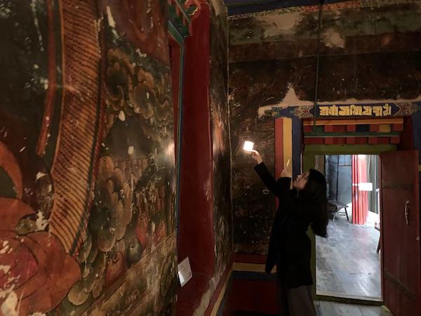 参观者拿着艺术中心特制的灯，细观壁画
