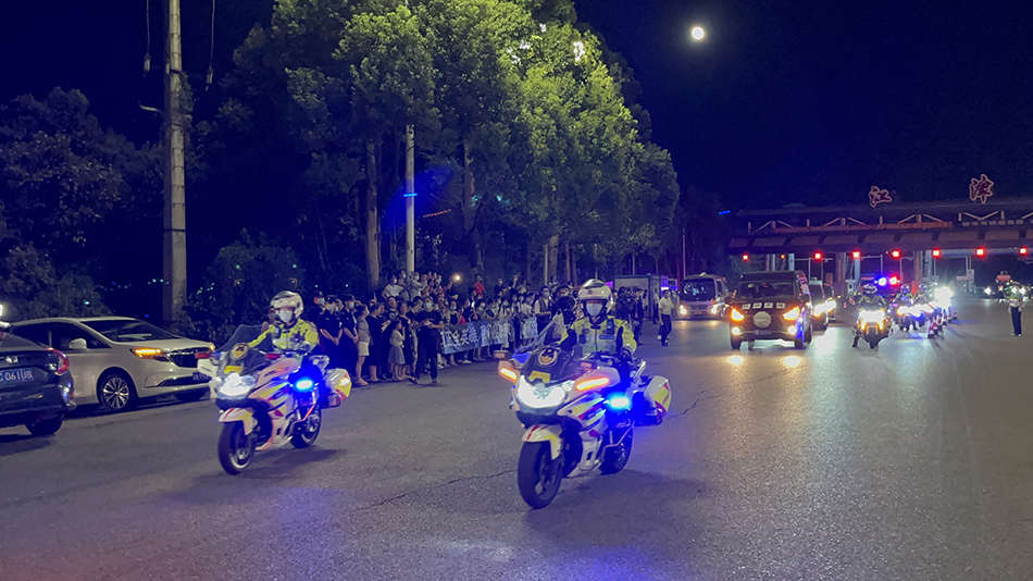 警车护送灵车前往殡仪馆。