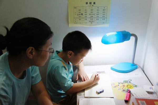 家长陪伴孩子做家庭作业 视觉中国 资料图
