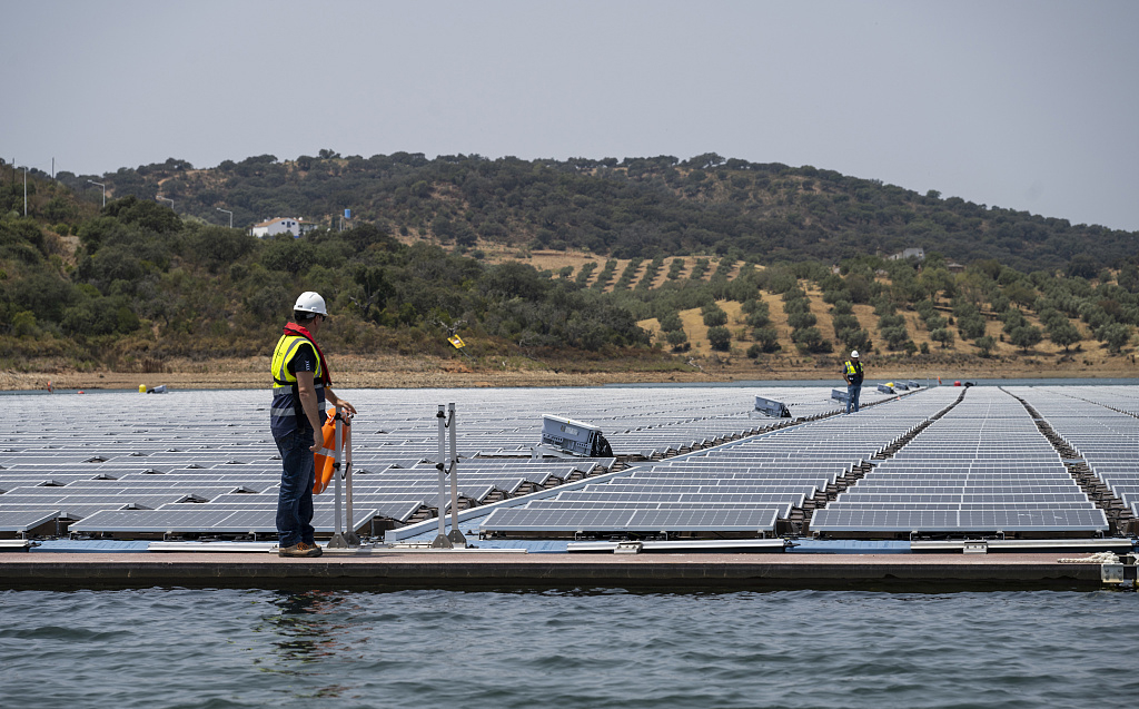 当地时间2022年7月15日，葡萄牙阿尔克瓦，浮动太阳能发电厂的工作人员。