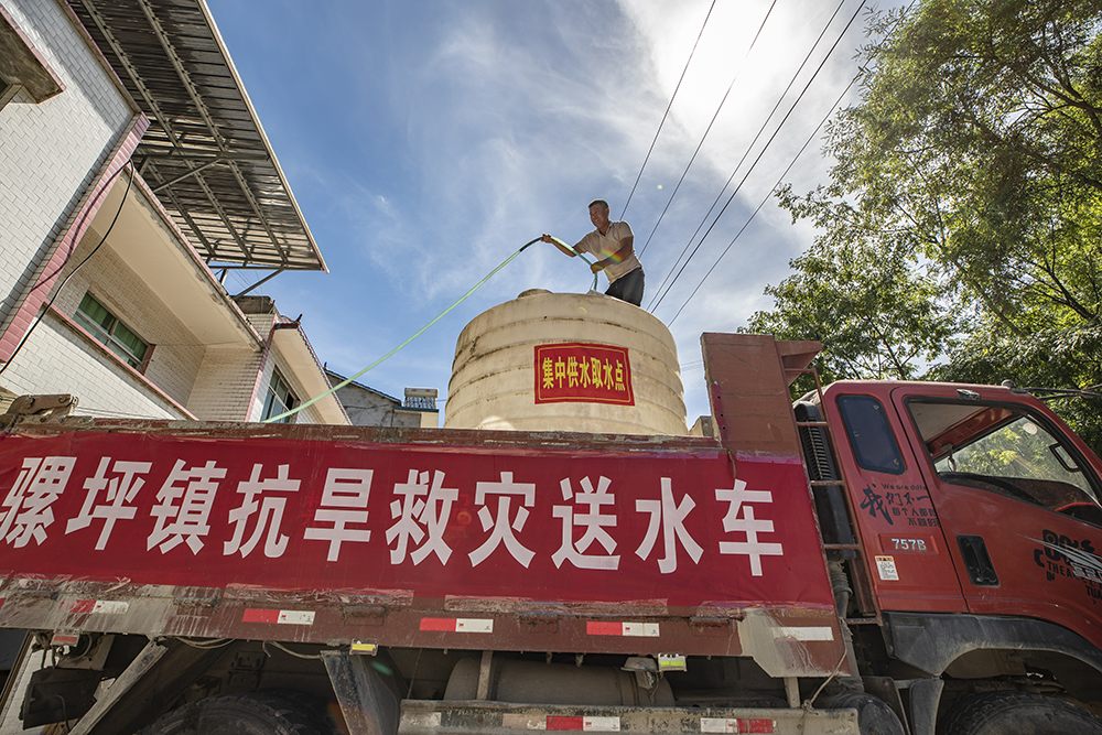 8月13日，在重庆市巫山县骡坪镇骡坪村，工作人员为村民送水。新华社 图