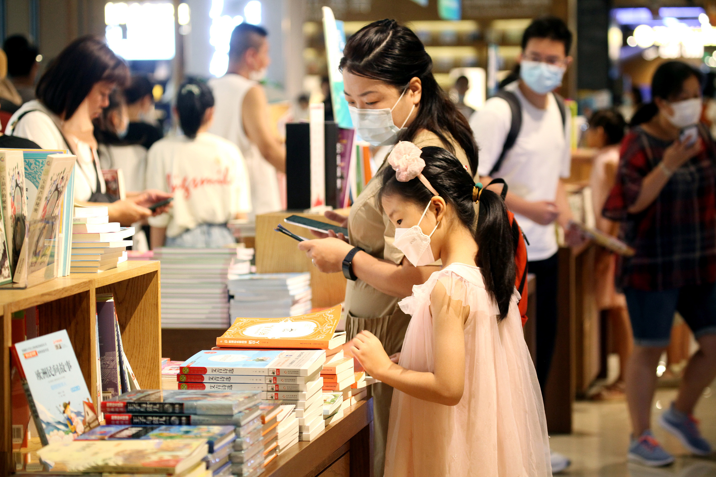 2022年8月18日，沈阳，许多家长带着孩子来到玖伍文化城教育书店选购新学期开学所用的相关书籍，为开学做准备。