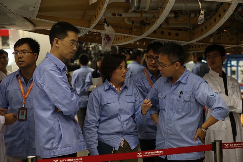 姜丽萍在C919大型客机发动机吊装现场(前排右二)