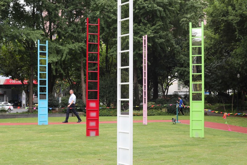 苏格兰艺术家吉姆·兰比作品《镜梯凝神》，结合其标志性色彩和现成品改造的特点，通过一座与众不同的互动迷宫，让人们在宛若交响乐的韵律中感受彩色梯子间的镜面交错，在凝视的过程中开启思考自我的旅程。