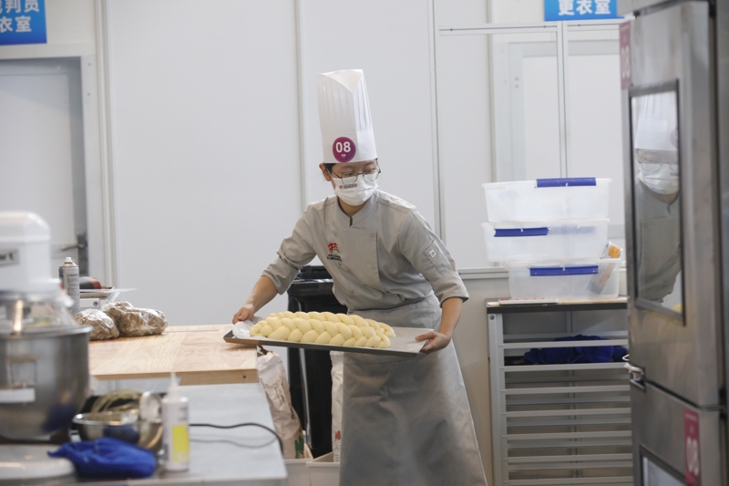 2023年9月16日，第二届全国技能大赛在国家会展中心（天津）开启。上海共142名选手赴天津参加本次大赛，他们将在全部109个项目展开比拼。这是上海选手朱玉洁在烘焙项目比赛现场。