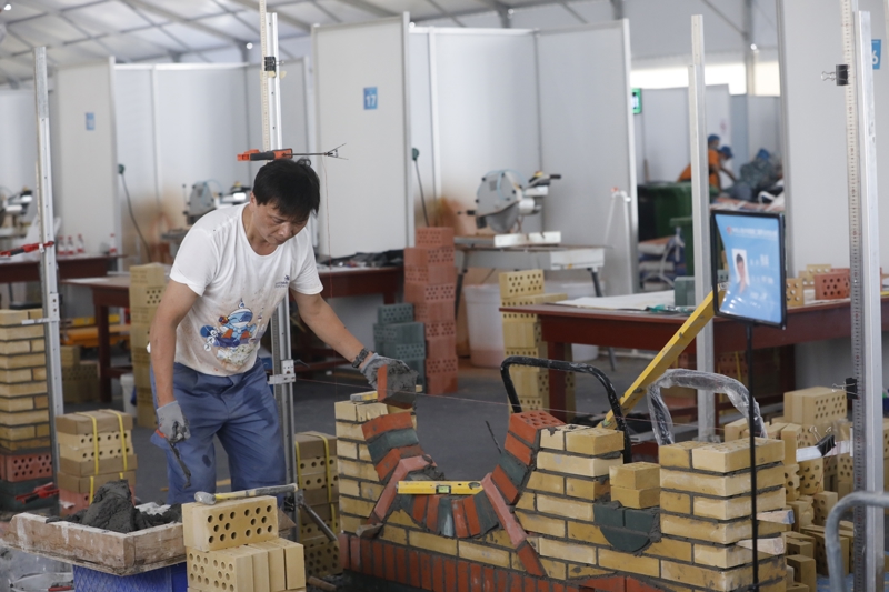 2023年9月16日，第二届全国技能大赛在国家会展中心（天津）开启。上海共142名选手赴天津参加本次大赛，他们将在全部109个项目展开比拼。这是上海选手杨从星在砌筑项目比赛中。