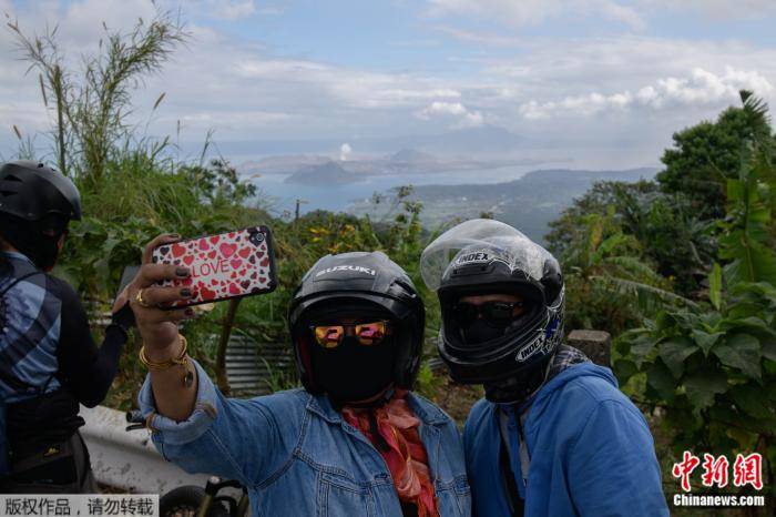 人们与菲律宾塔阿尔火山自拍留念。来源：法新社