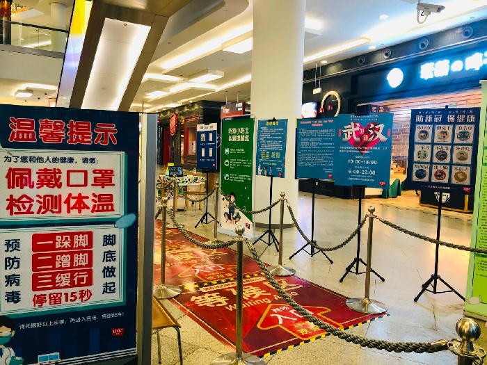 中心一家服装店的玻璃窗上,粘贴着提示信息:进店请登记,限流34人等